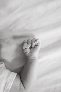 A black and white photo of a newborn baby hand, shot taken by Vanessa Montano, a Danville Photographer