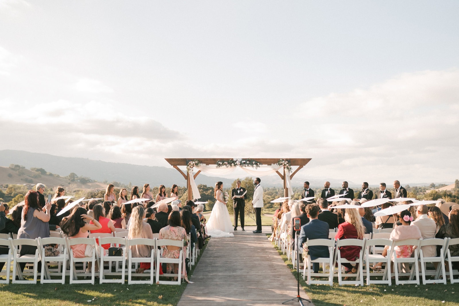 A look down the aisle at one of the outdoor hilltop wedding venues in Brentwood, CA as the bride and groom stand facing each other