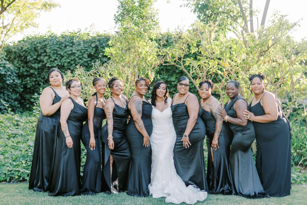 Wedding party posing for a photo at Brownstone Gardens by Vanessa Montano