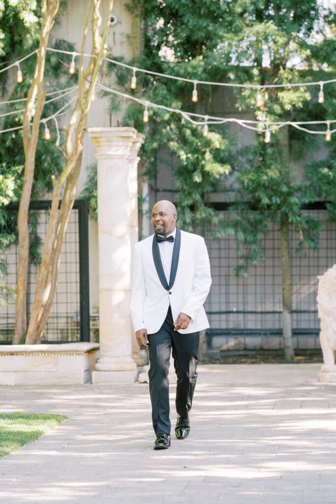 Groom walking down the isle looking at guests smiling Brentwood Wedding Photographer