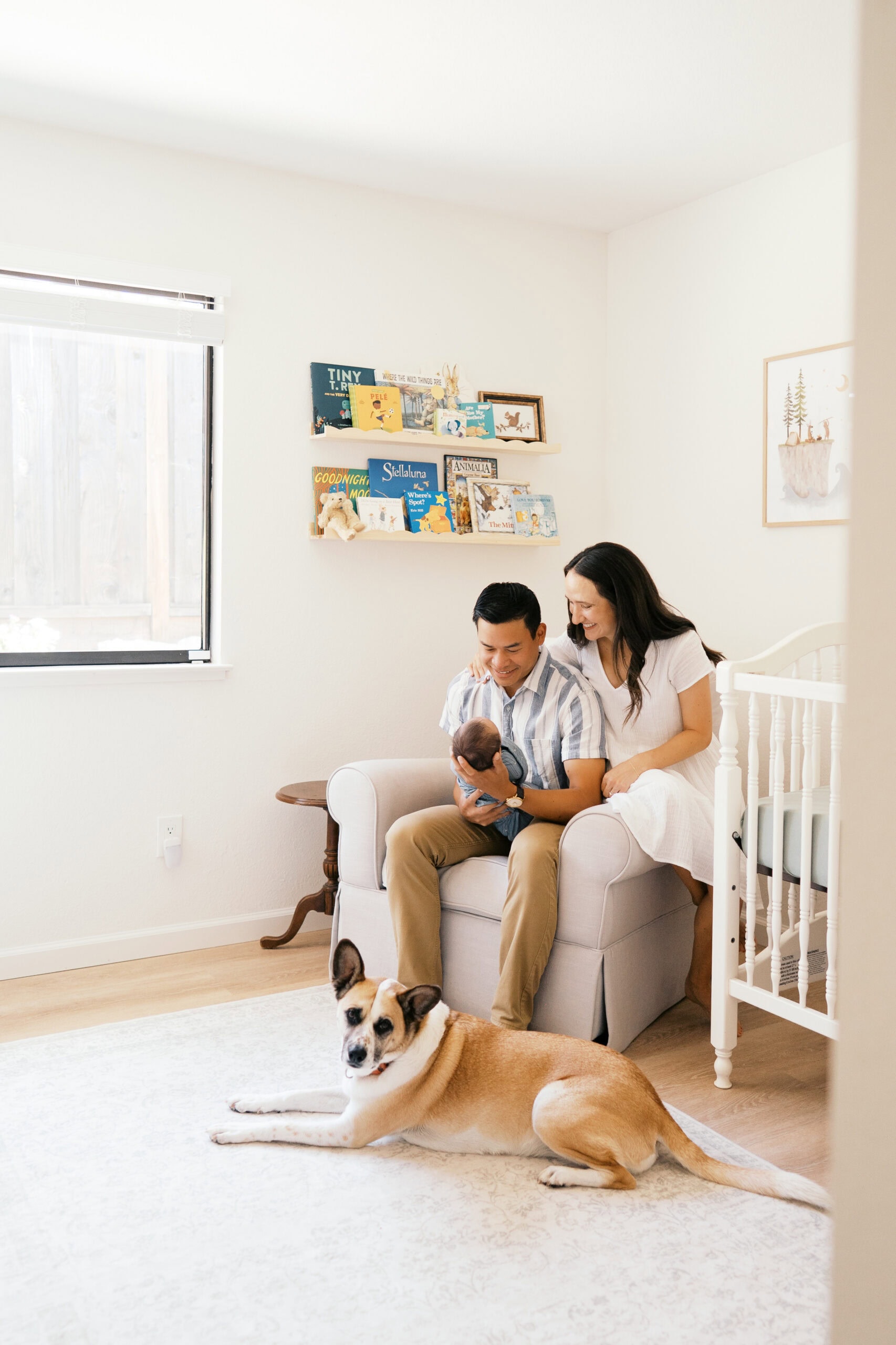 Family coordinating soft, neutral outfit tones for a photoshoot that includes their dog