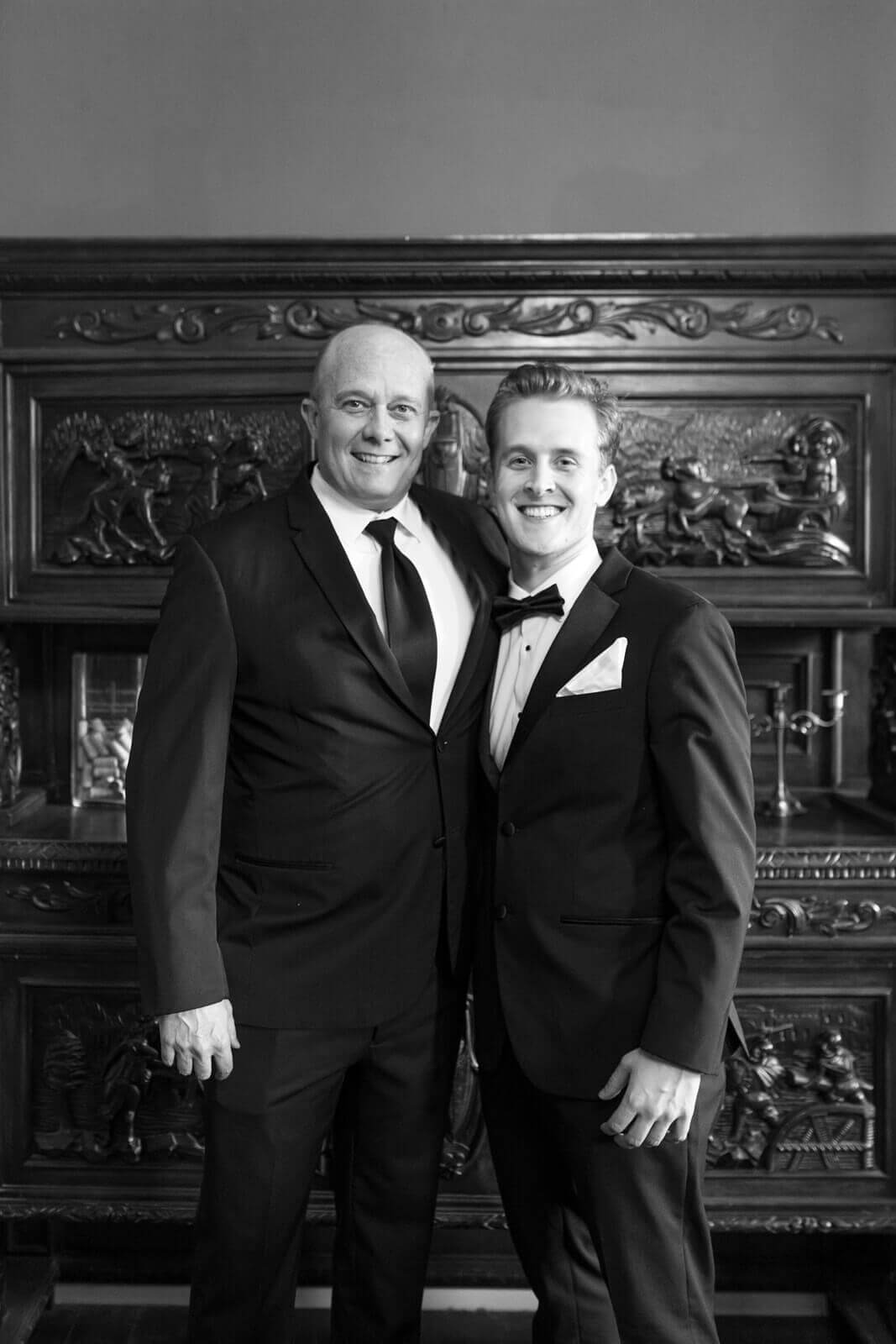 Groom poses with a family member beside the historic woodwork inside Elliston Vineyards before the wedding ceremony.