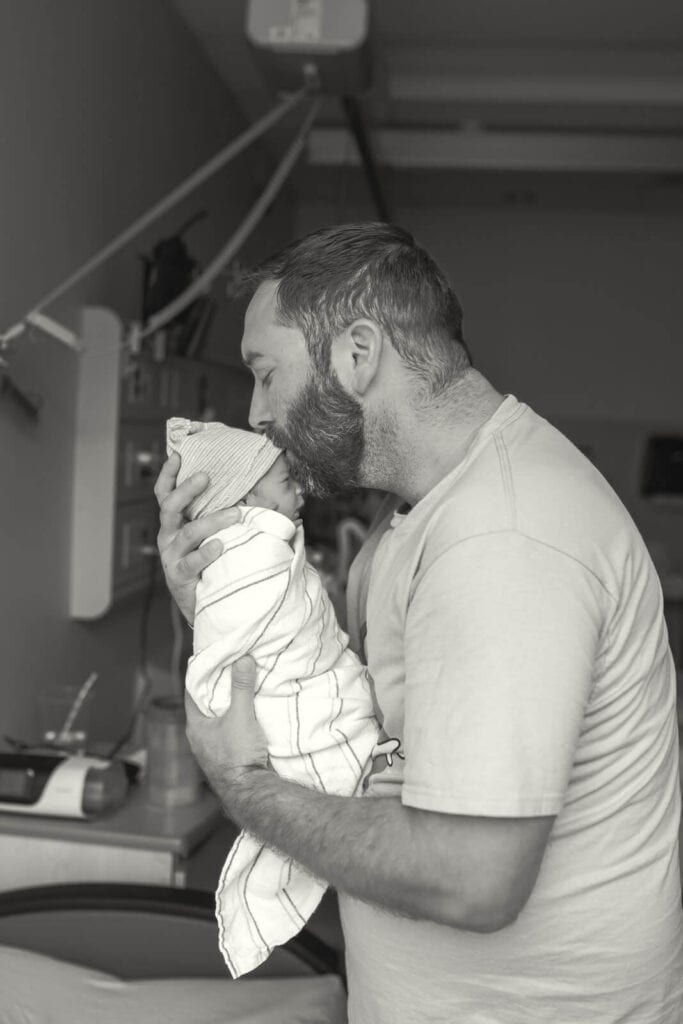 Father holding his newborn baby during a Bay Area hospital newborn photography session