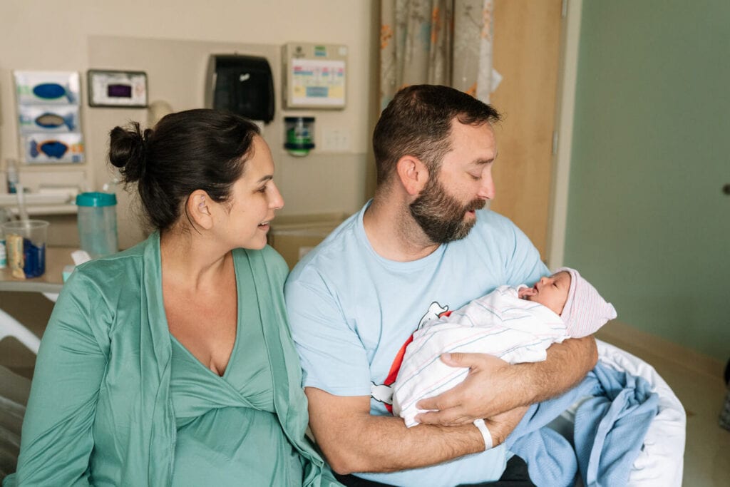 Parents admiring their newborn baby during a documentary-style Bay Area Fresh 48 session